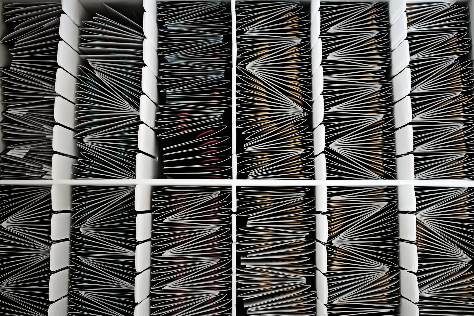 Top view of neatly organized documents divided by separators in a container.