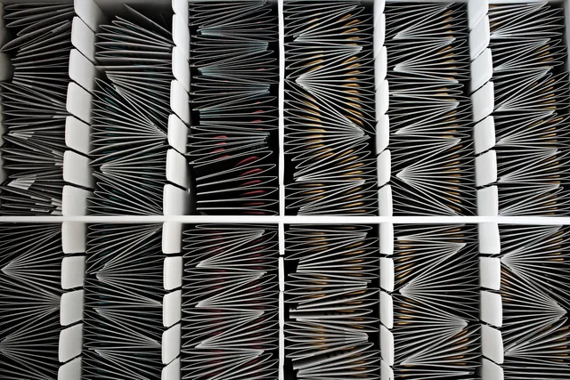 Top view of neatly organized documents divided by separators in a container. Dateien und Entwürfe auffindbar ablegen